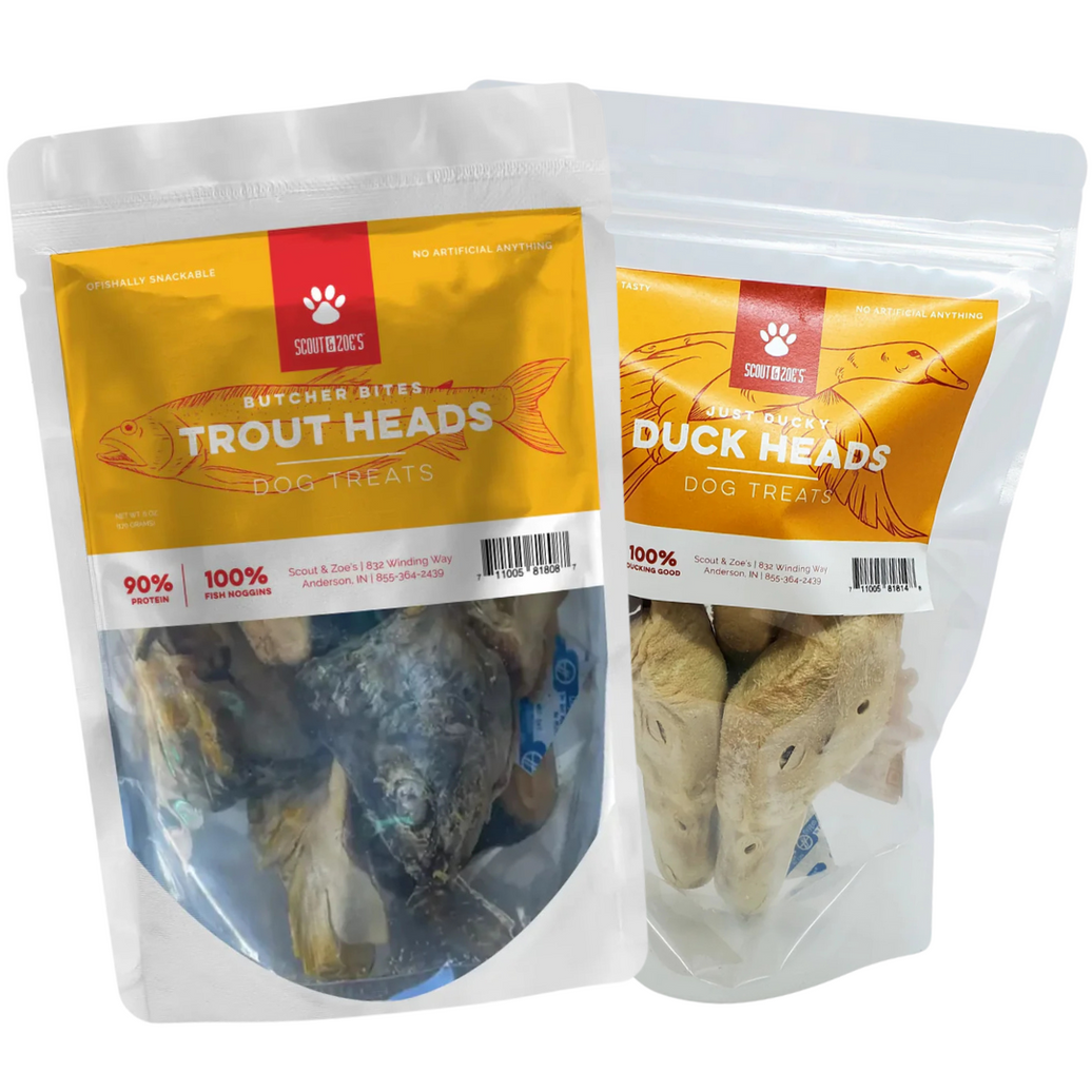 Two packages of dog treats, one labeled 'Trout Heads Dog Treats' and the other 'Duck Heads Dog Treats', each showing the respective animal heads inside.